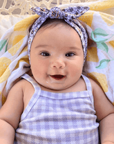 Little girl is wearing a comfortable baby headband for little girls from By Bella Boutique.